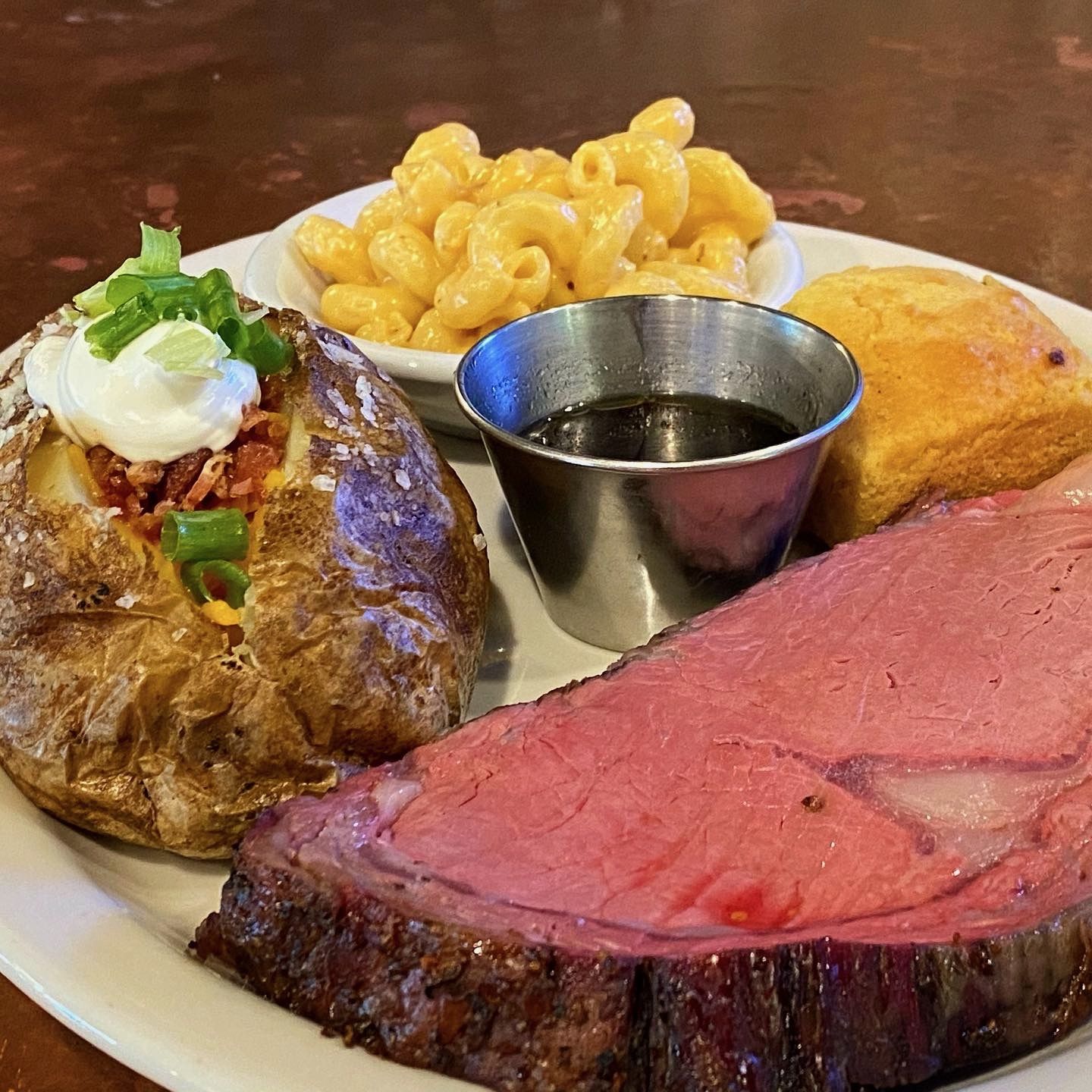 Prime Rib dinner with loaded baked potato and bacon mac and cheese. Served with au jus and jalapeno cornbread muffin.