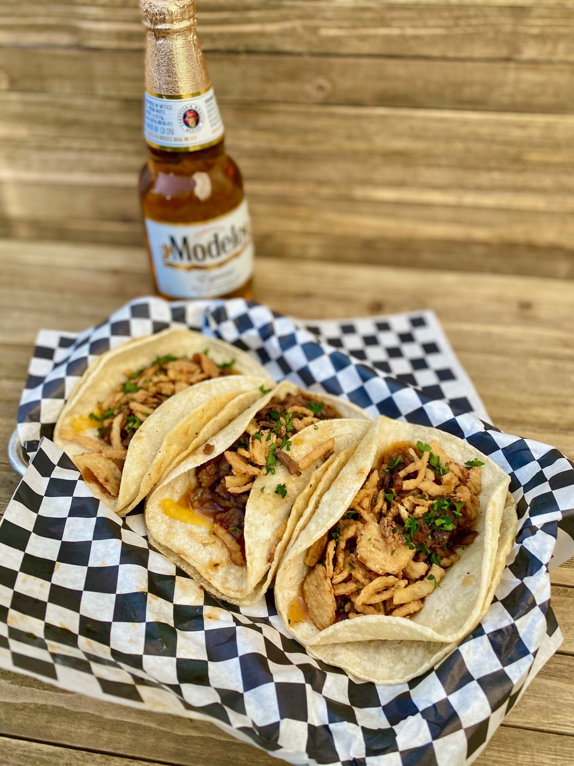 3 tacos with negro modelo in the background